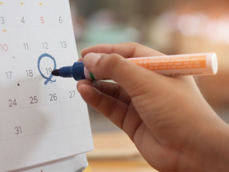 persona che cerchia una data sul calendario