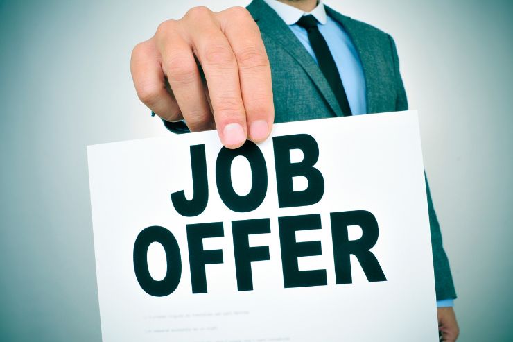uomo che tiene in mano foglio scritto 'job offer'